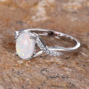 Stunning silver twisted ring featuring an oval white opal and sparkling cubic zirconia.
