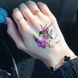 Waterproof temporary tattoo sticker featuring a vibrant hummingbird and purple floral design for hand.
