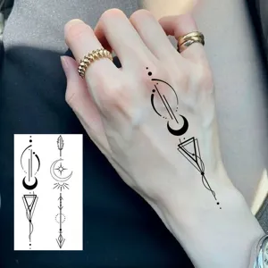 Tatuaggio temporaneo con motivo geometrico di luna e stelle applicato sul dorso della mano.
