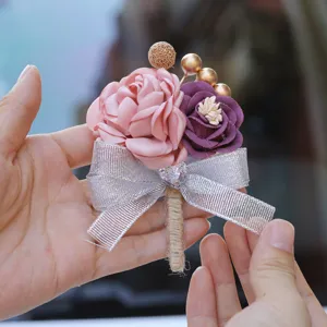 Close-up detail of a Korean style wedding boutonniere with pink purple flowers and silver bow.