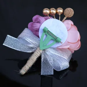 Detailed view of the wedding boutonniere back, showing pin and ribbon construction.