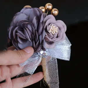Elegant grey purple fabric flower wedding boutonniere with glitter bow and gold beads.
