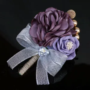 Exquisite purple fabric rose boutonniere detail with silver glitter ribbon and crystal heart.