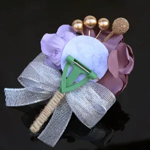Detailed view of wedding groom boutonniere corsage with silver bow and purple fabric flowers.