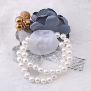 Detail view of wedding corsage wrist flower featuring grey fabric flower pearls and silver ribbon.