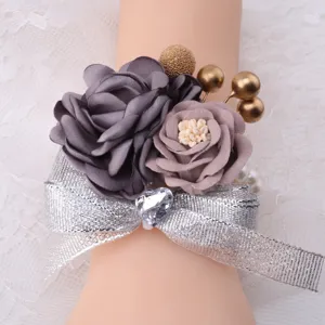 Exquisite wedding wrist corsage detail, featuring grey fabric roses and silver ribbon.