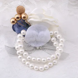 Detailed close-up of Korean style wedding wrist corsage with white flowers and pearls.