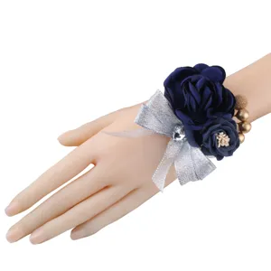 Detailed view of navy blue artificial rose wrist corsage with silver glitter bow and rhinestones.
