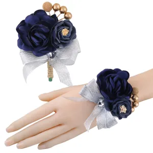 Details of dark blue artificial rose wrist corsage and boutonniere set with silver bow.
