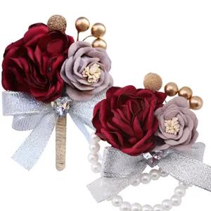 Handmade wedding corsage set with artificial roses, silver bows, and pearls for bride and groom.