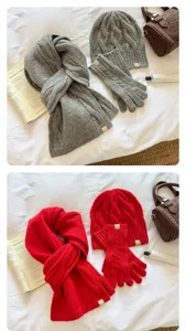 Detailed close-up of winter cozy cable knit scarf, beanie hat and gloves set texture.