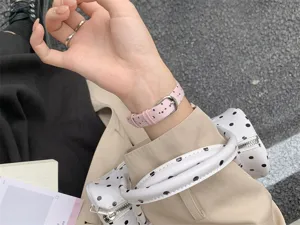Dettaglio cinturino per smartwatch lavorato a maglia a pois stile coreano, cinturino in tessuto morbido.