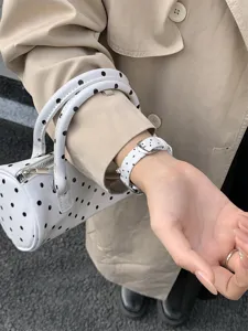 Detail van chique wit polstbandje met stipjes, compatibel met Apple Watch, stijlvol accessoire.