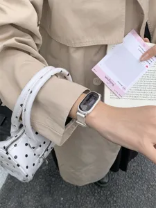 Primo piano dettagliato di un elegante cinturino per smartwatch lavorato a maglia al polso.
