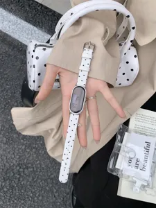 Vista dettagliata del cinturino per smartwatch a pois bianchi con fibbia in metallo.