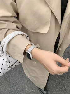 Vista dettagliata del cinturino di ricambio per smartwatch argentato con grazioso ciondolo.