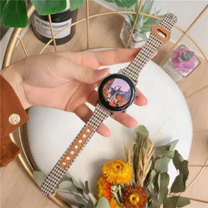 Λεπτομέρεια λουρακιού smartwatch με μοτίβο πιε ντε πουλ, καμβάς και δέρμα υψηλής ποιότητας.