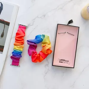 Detailaufnahme eines bunten Regenbogen Stoff Scrunchie Uhrenarmbands mit passendem Haargummi.