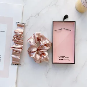 Detailansicht des rosa Samt Scrunchie Uhrenarmbands und passenden Haargummis im Set auf Marmor.