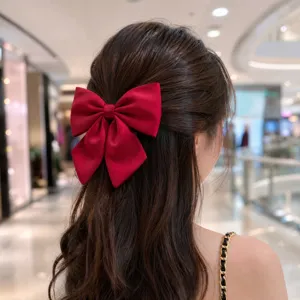 Grande pince à cheveux nœud en satin rouge pour femmes, accessoire élégant pour coiffure.
