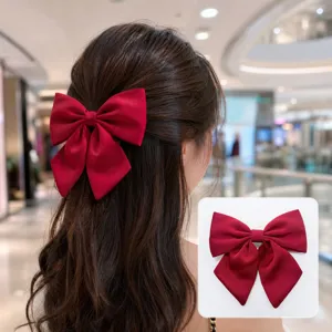 Vue détaillée de l'élégant pince à cheveux nœud en satin rouge portée sur la tête.