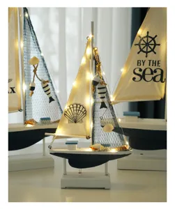 Detailed view of the nautical wooden sailboat decor with warm LED lights, coastal style.