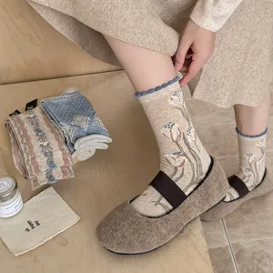 Gros-plan de chaussettes mi-hautes florales rétro avec bord roulé et joli motif de tulipes.