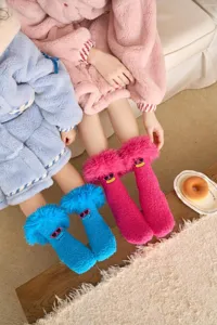 Détail de polaire corail douillette, visage de lunettes de soleil drôle, chaussettes.