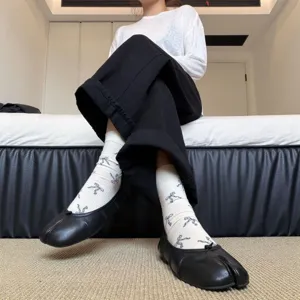Detailaufnahme von Retro Schleife Split-Toe Socken kombiniert mit schwarzen Tabischuhen.