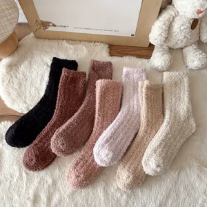 Primo piano di morbide e accoglienti calze in pile corallo multicolore esposte su un tappeto.
