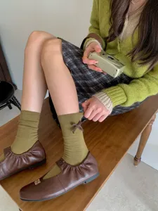 Bellissimi calzini al polso verde oliva da donna con grazioso fiocco e tessuto morbido.