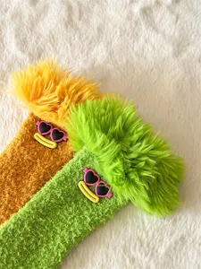Gros plan de chaussettes douillettes en molleton avec cheveux drôles et lunettes de soleil.