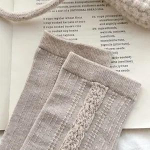 Gros plan détaillé de chaussettes mi-mollet en tricot côtelé beige avec revers vintage.
