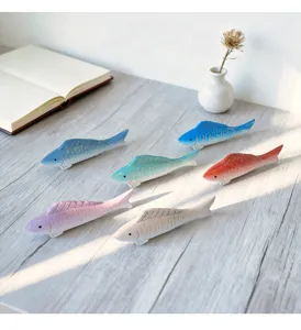 Close-up of Mediterranean wooden fish figurines set, handmade colorful desktop decor.
