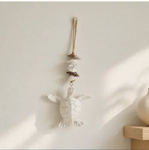 Detailed close-up view of coastal style sea turtle wall hanging with shells and natural twine.
