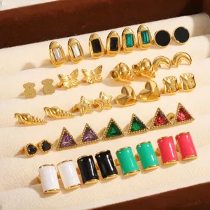 Vista detallada de pendientes dorados con diseños geométricos y esmaltados de moda.