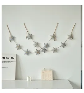Dettaglio ghirlanda di stelle in tessuto con motivi carini e piccoli bottoni di legno.
