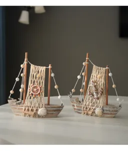 Close-up view of vintage wooden sailboat models with fishing nets, shells, and rope decor.