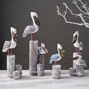 Mediterranean wooden pelican bird figurine set on tree stump base for stylish home decor display.