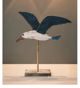 Detailed view of a vintage wooden flying seagull sculpture ornament, coastal style decor piece.