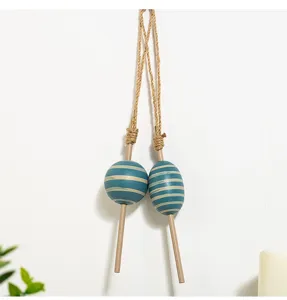 Mediterranean wooden float hanging decor with blue striped balls and jute rope for wall art.