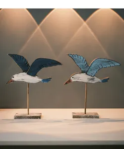 Detailed close-up view of coastal vintage wooden seagull ornaments, ideal for marine room decor.
