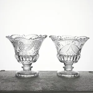 Vue détaillée de deux coupes à dessert en verre gaufré transparent au motif vintage classique.