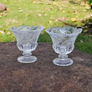 Gros plan détail de coupes à dessert en verre transparent gaufré sur pierre en extérieur.
