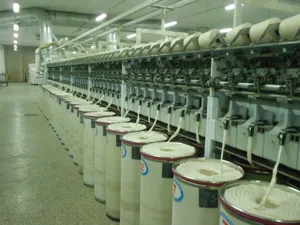 Fabrieksproductielijn met moderne textielspinmachines en katoenbussen in de werkplaats.