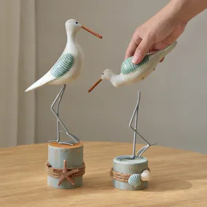 Wooden seagull figurine nautical style tabletop decor with tree stump base and shell accents.
