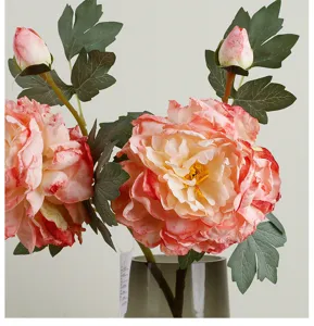 Vue détaillée de fleurs de pivoine en soie artificielle avec bords brûlés dans un vase.
