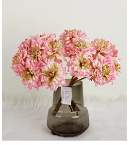 Vue détaillée d'un bouquet de dahlias roses artificiels dans un vase en verre gris pour déco.
