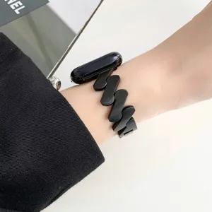 Nahaufnahme des gewellten Edelstahluhrarmbands am Handgelenk mit schwarzem Metallgliederdesign.