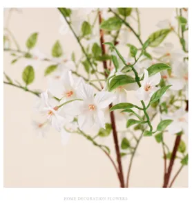 Detailopname van kunstmatige witte bloemen met groene bladeren voor mooie huisdecoratie.